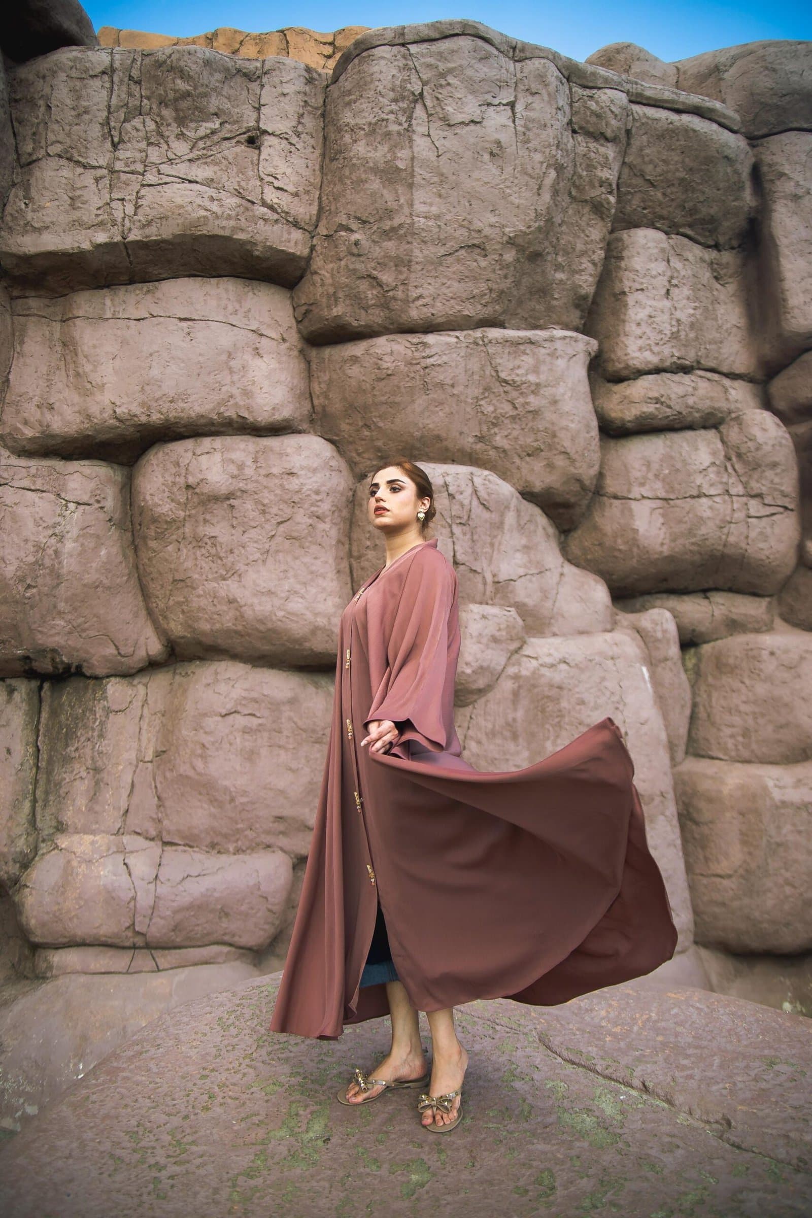 Model in a flowing dress against a desert rock formation