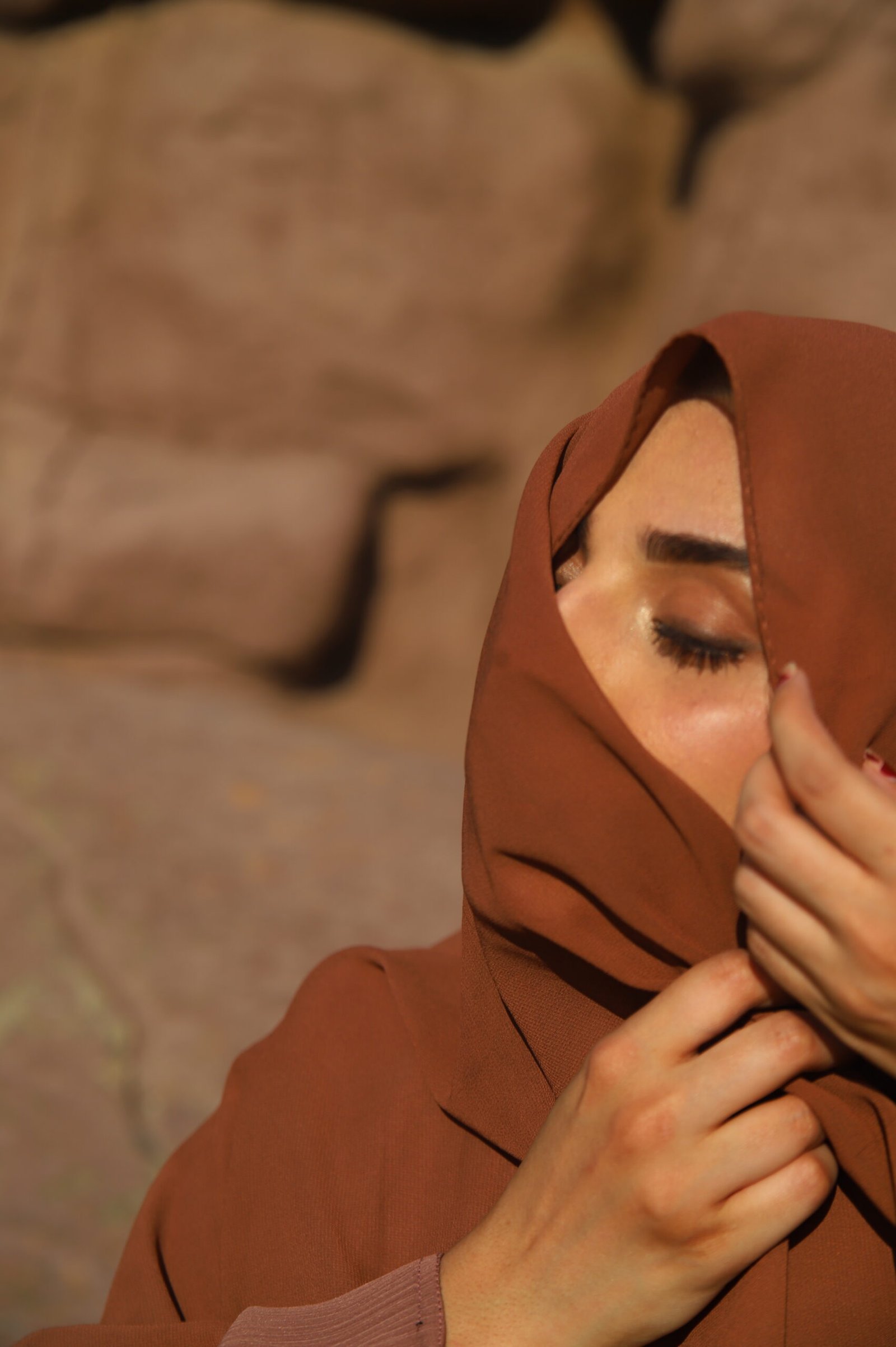 Model in a flowing abaya against a warm desert backdrop
